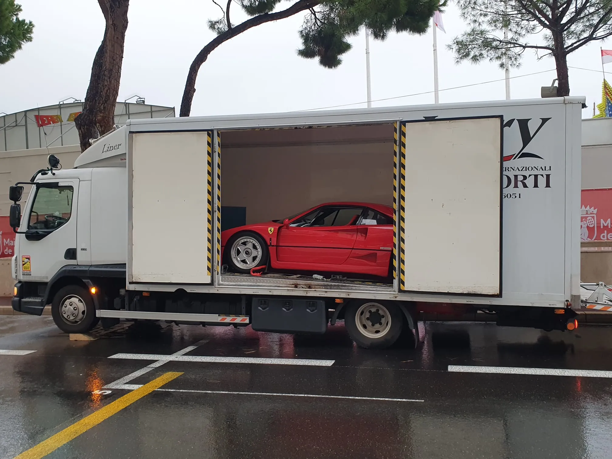 Ferrari F40 rossa nel furgonato Lory con le porte laterali aperte, sotto la pioggia