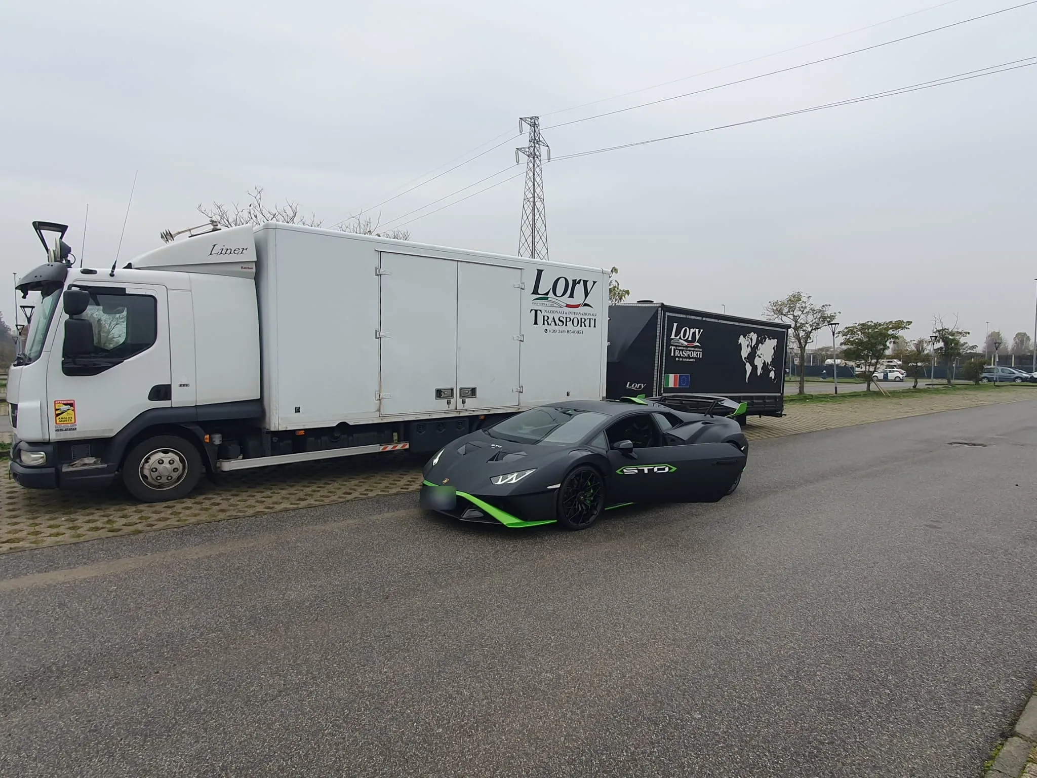 Motrice e rimorchio Lory Trasporti con una Huracán STO nera parcheggiata davanti